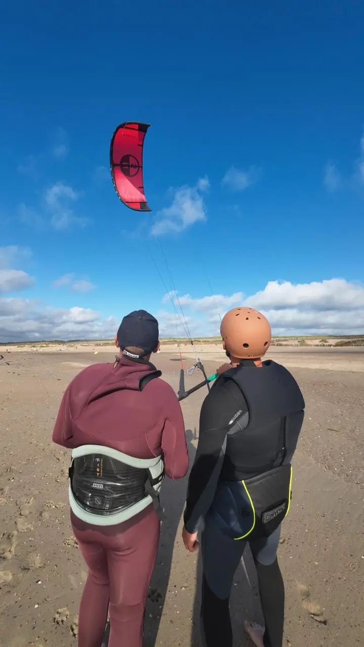 Kitesurfles op Brouwersdam — instructeur en leerling op het strand